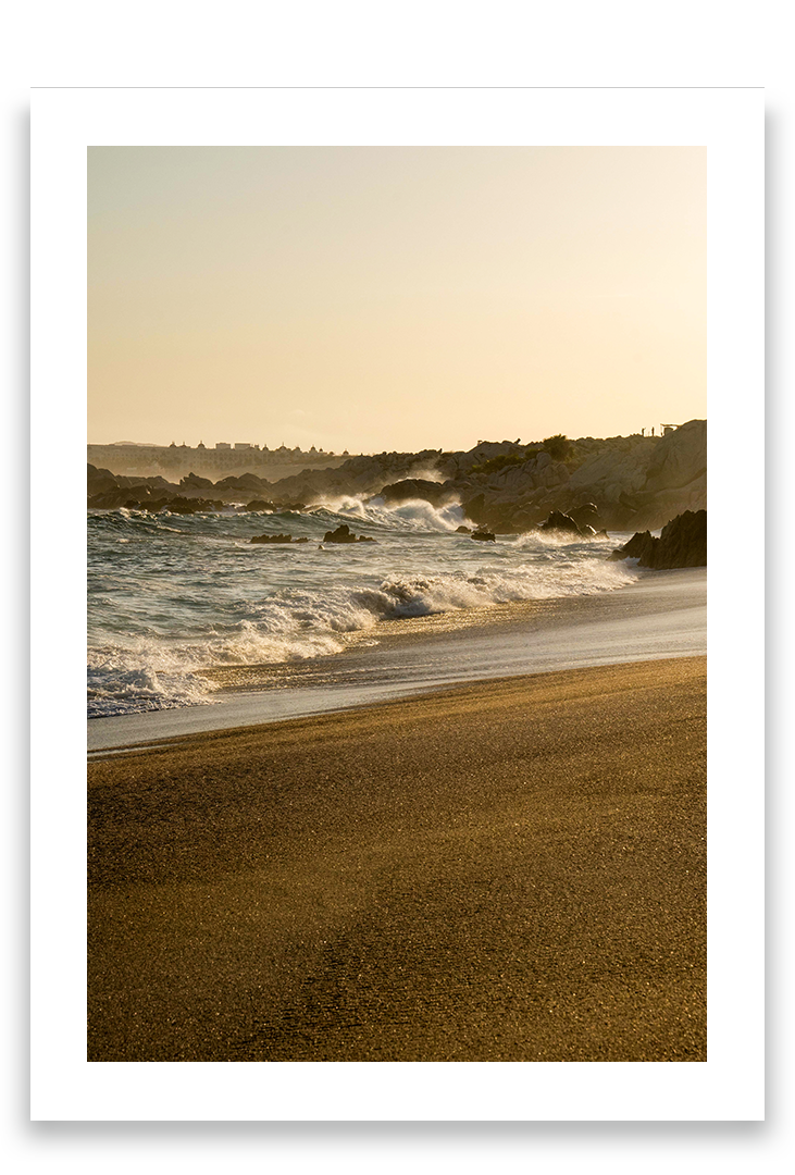 Waves crashing on sand, golden hour