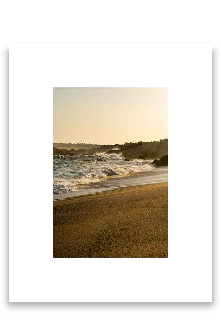 Waves crashing on sand, golden hour