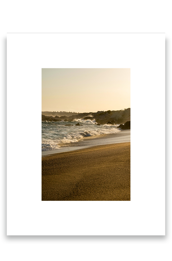 Waves crashing on sand, golden hour