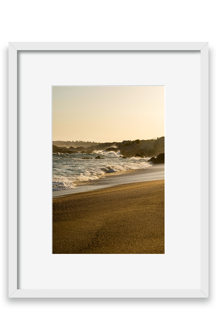 Waves crashing on sand, golden hour